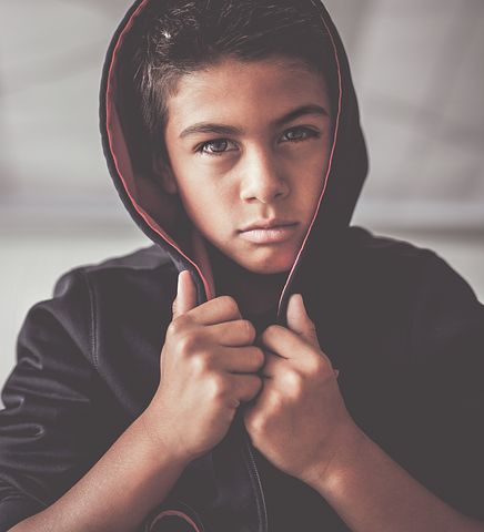 Photo of boy with hood looking at the camera