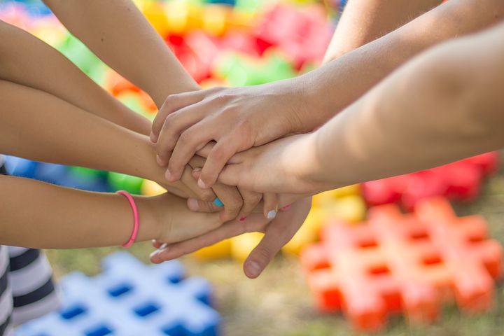 Photo of kids with their hands together in the middle