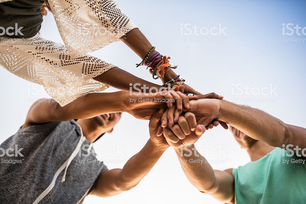 Photo of three people with their hands in to cheer