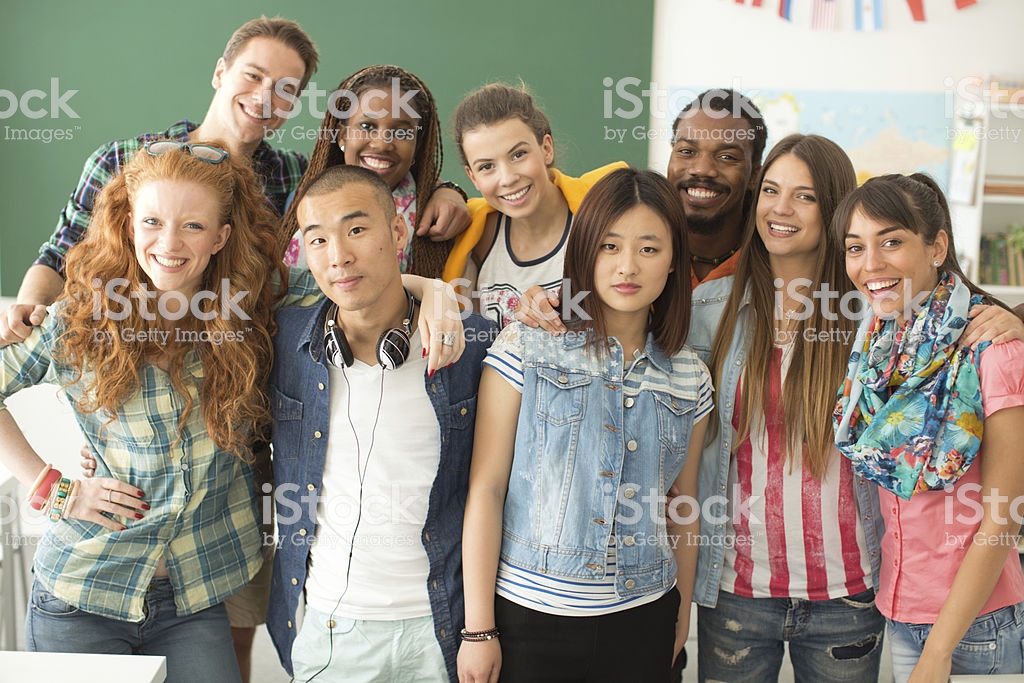 Photo of a group of college students in a classroom looking at the camera