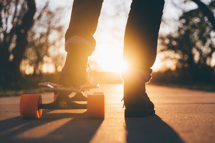 Photo of feet, with one on a skateboard