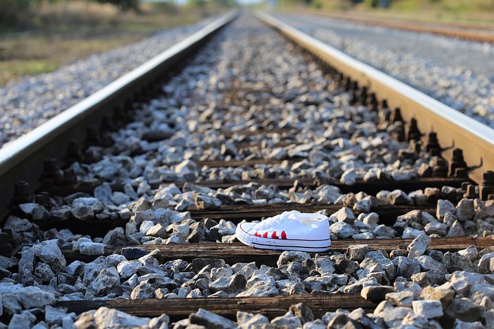 Photo of one sneaker on train tracks