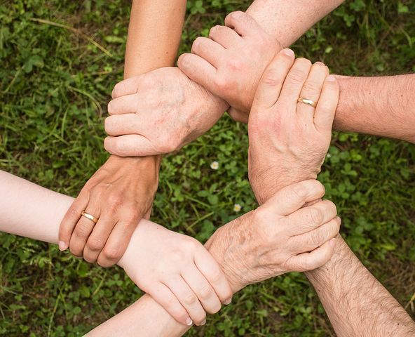 Photo of hands holding each other's wrist to form a circle
